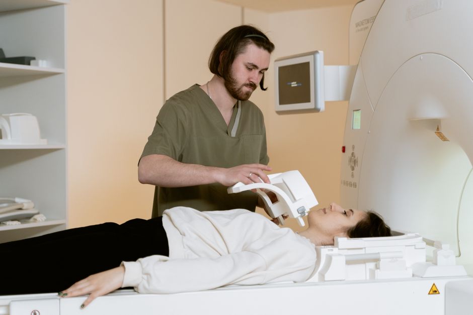 A healthcare worker prepares a patient for an MRI scan in a modern medical facility.